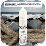 Boink Smash Strawberry Spearmint e-liquid bottle on a beach with ocean and rocks in the background