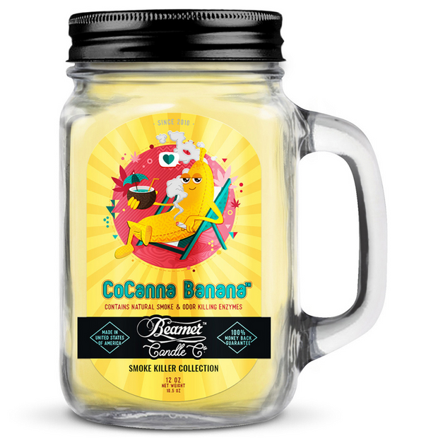 Glass jar candle with colorful label featuring a banana character, labeled 'CoCanna Banana', on a white background.