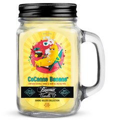 Glass jar candle with colorful label featuring a banana character, labeled 'CoCanna Banana', on a white background.